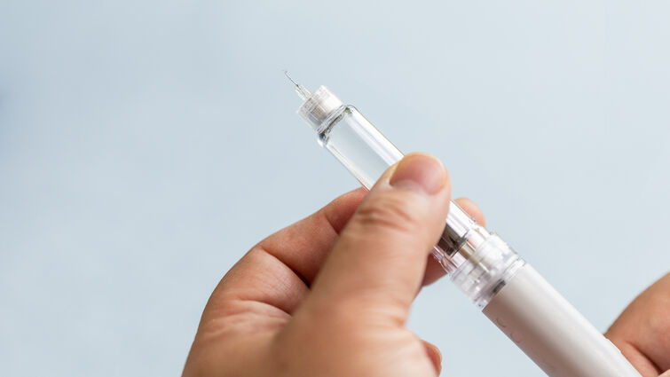 woman preparing a GLP-1 semaglutide injection pen at home.