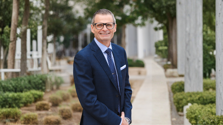 Dr. Hilliard wearing a blue suit and smiling at the camera 