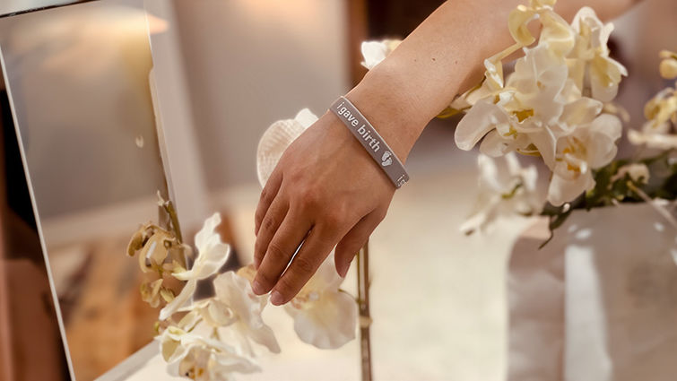 close up of a woman wearing an "I gave birth bracelet" arounod her wrist