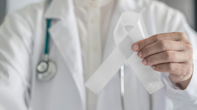 Physician holding white ribbon for lung cancer awareness 