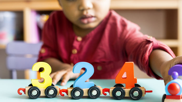 Little boy playing mathematics wooden toy at nursery