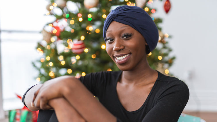 Woman with headscarf sitting in front of Christmas tree