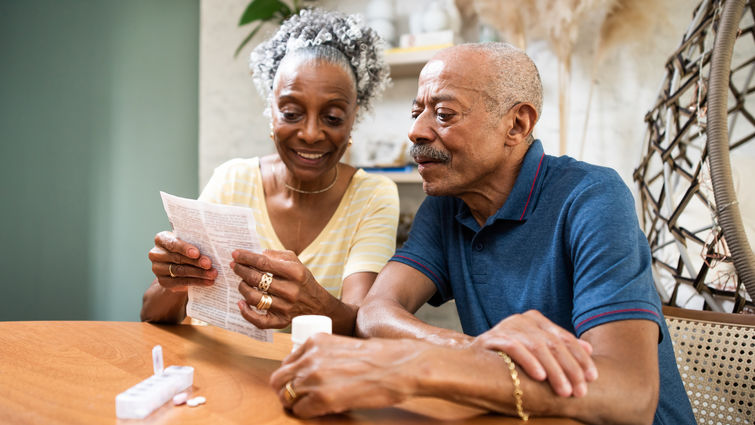 Older couple reading paper at table