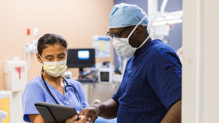 Two doctors discussing patient chart in ICU