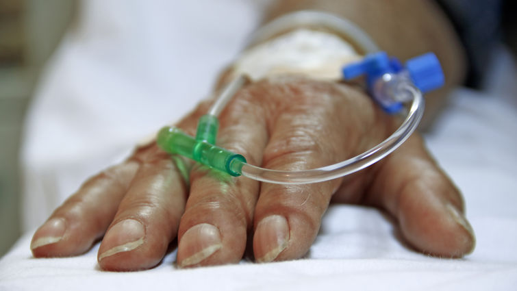 Close up shot of IV in older person's hand