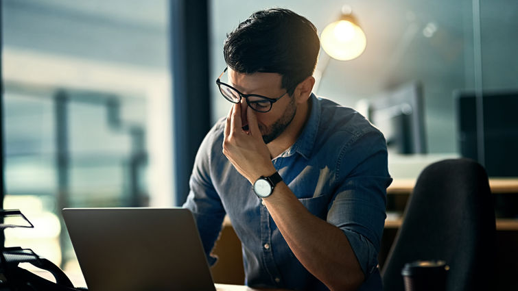 Stock image of young man stressed at work
