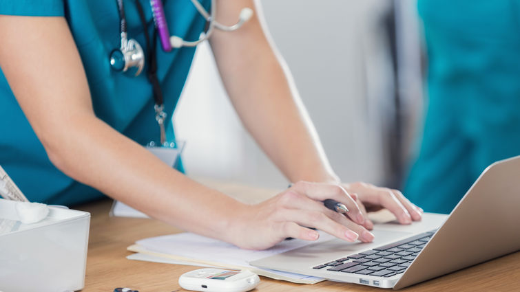 Women physician typing on computer