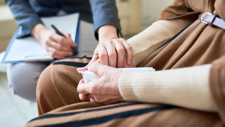 Clinician holding hand of elderly patient