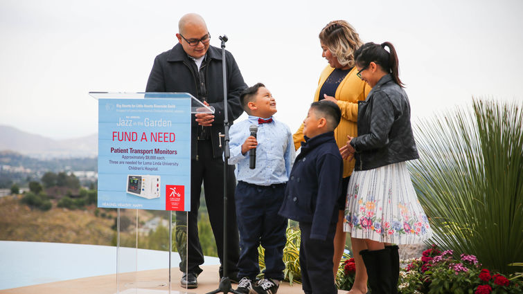 hispanic family stands together by glass podium