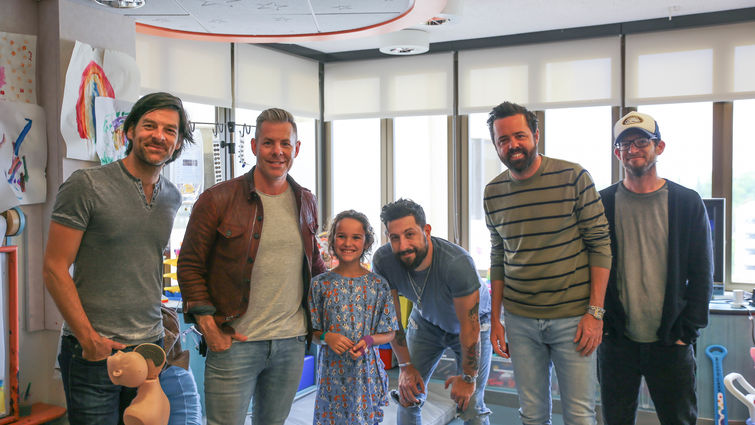 five members of country band poses with young female patient