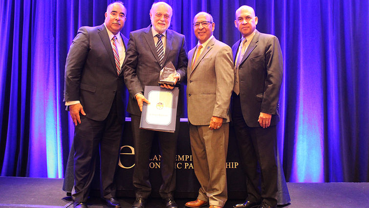 From left: Paul Granillo, Inland Empire Economic Partnership president and CEO; Richard H. Hart, MD, DrPH, president of Loma Linda University Health; Marco Robles, IEEP board chair; and Al Arguello, member at large, IEEP executive board. Four men pose in front of curtain