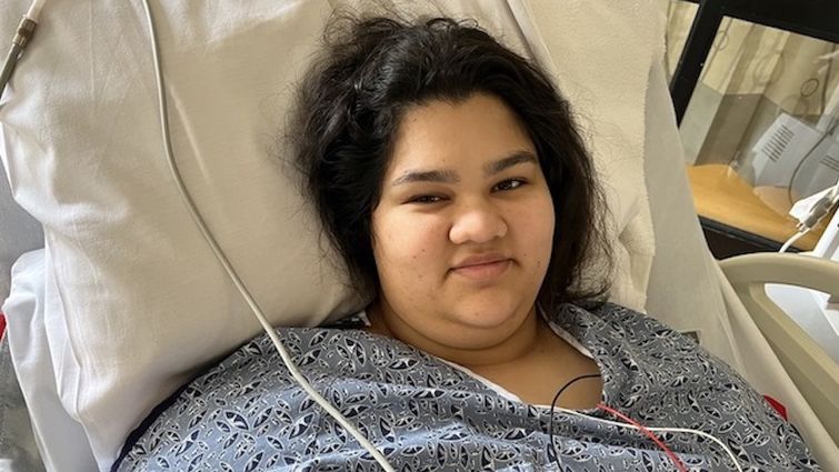Samara Serafini, 15, treated at Loma Linda University Children's Hospital Teenge girl in hospital gown and hooked up to wires lies in bed and smiles at the camera