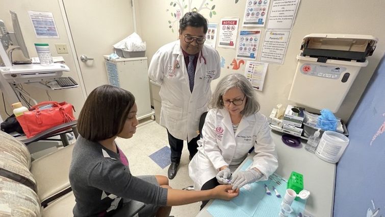 Doctors in a clinic room screening a patient for sickle cell disease