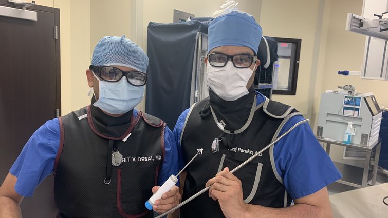 From left, cardiologists Harit Desai, MD, and Niraj Parekh, MD, hold surgical equipment used to repair patients’ heart valves during TMVr — a procedure that saved Elenita Tan’s life in December 2020.