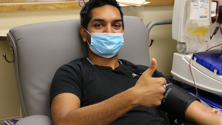 male sitting in chair giving blood