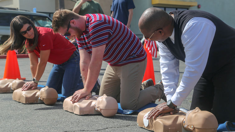 three people learning hands-only CPR