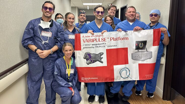 Cardiology team stand together in a hallway holding a large banner that reads “VARIPULSE Platform.” 