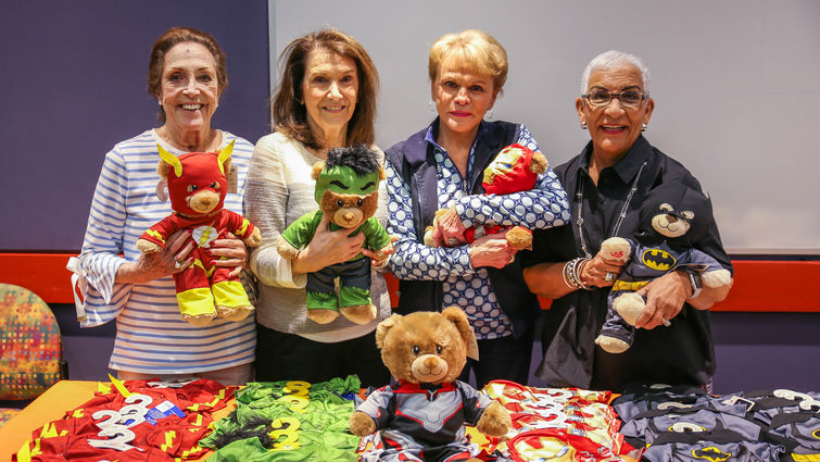 four elderly women holding teddy bears
