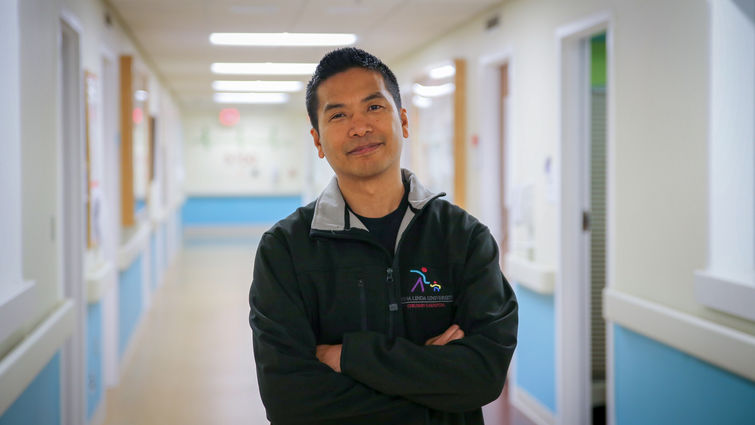 physician standing in empty hospital hallway