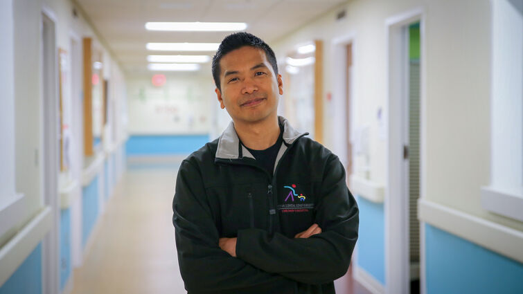 physician standing in empty hospital hallway