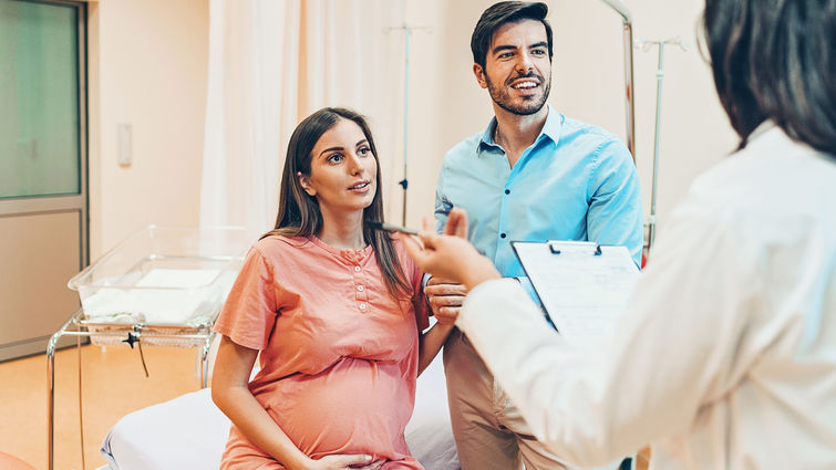 Husband and wife talking to the doctor in the hospital