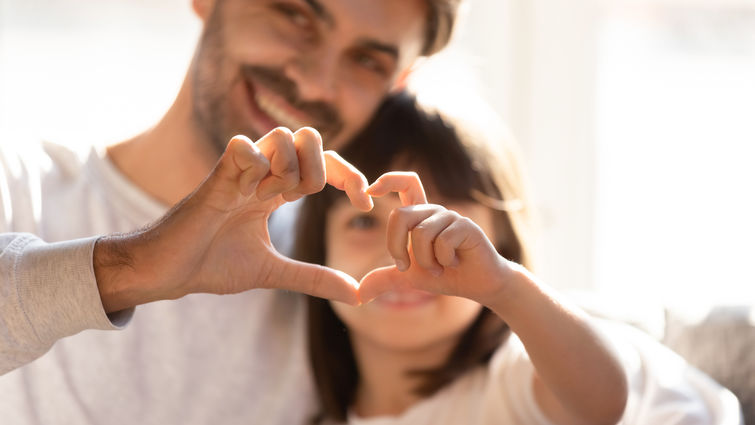 Family members form a heart with their hands.