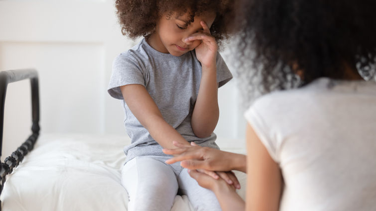 mixed race mom comforts young daughter