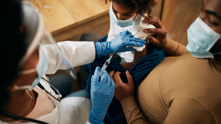 Close-up of doctor vaccinating African American girl during coronavirus pandemic