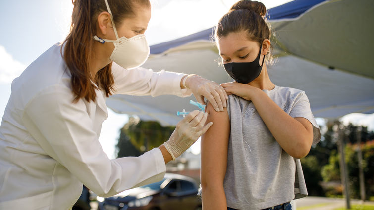 female physician vaccinates teenage girl