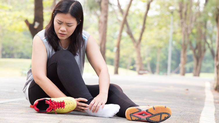 Female holding her ankle in pain