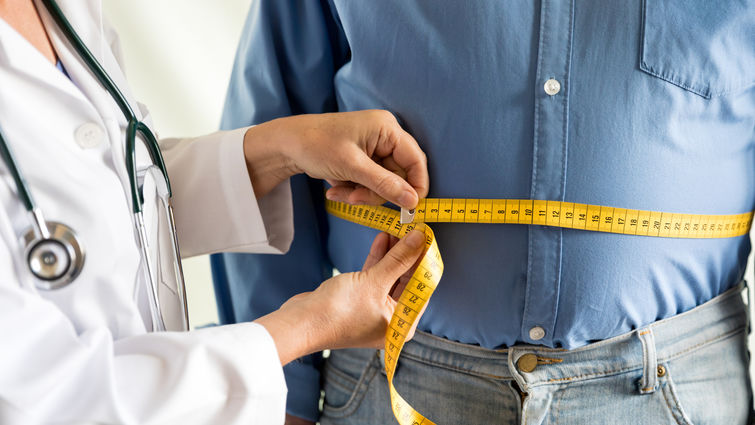 Obese man being measured by doctor