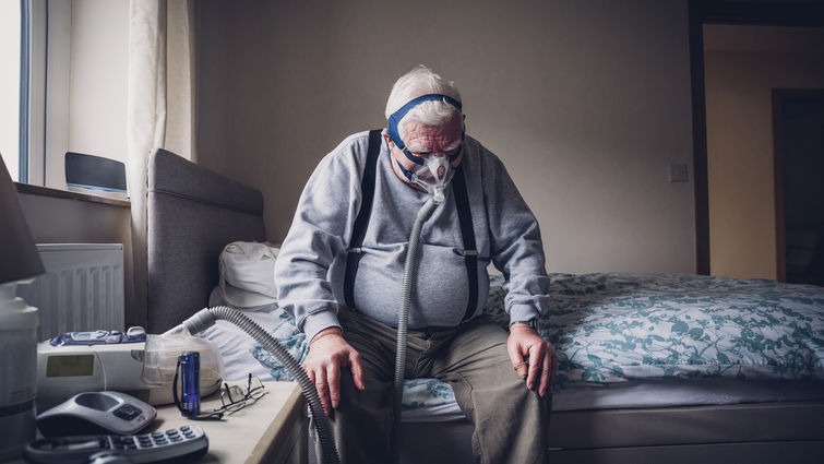 Elderly Man Using a Medical Breathing Apparatus stock photo