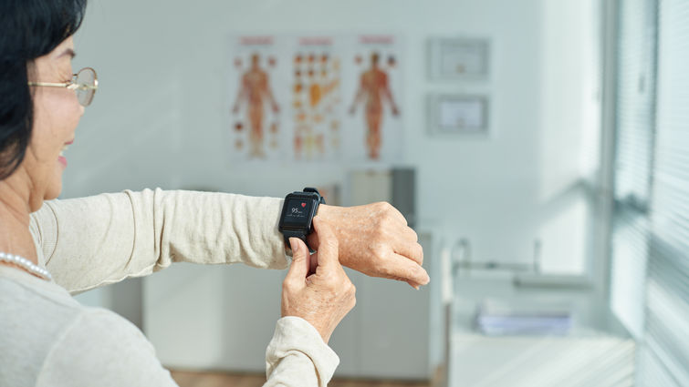 Elderly woman looking at heart rate display on smart watch