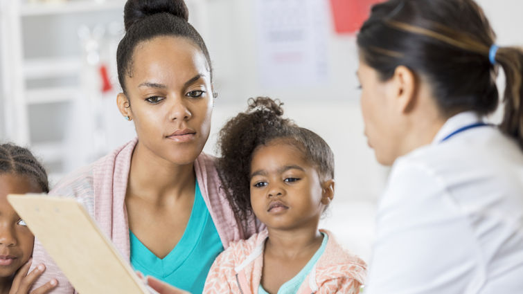 mother and young daughter discussing medical test results with doctor