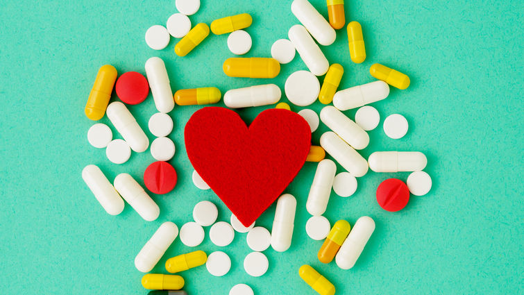 Heart cutout on backdrop of medical pills