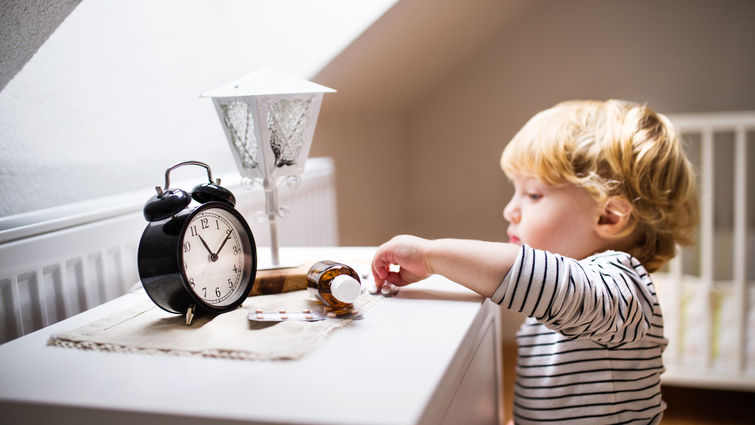 toddler boy reaching for pills on nightstand