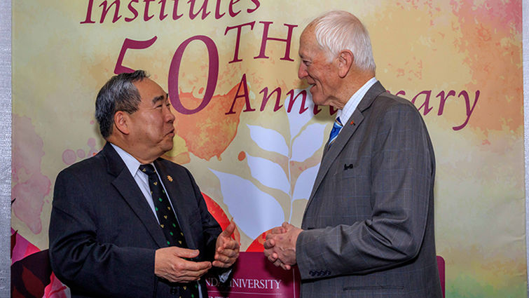 Infant heart transplant pioneer Leonard Bailey, MD, speaks with former acting Surgeon General Kenneth Moritsugu, MD, MPH, at the 50th anniversary celebration of organ transplantation at Loma Linda University Health. Two men shake hands