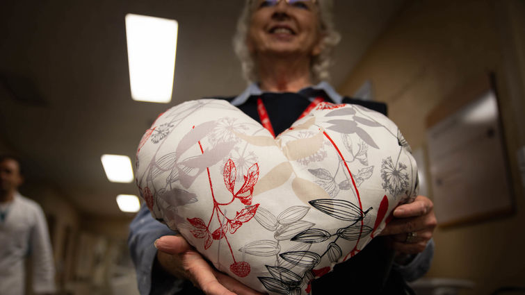 woman holds heart pillow