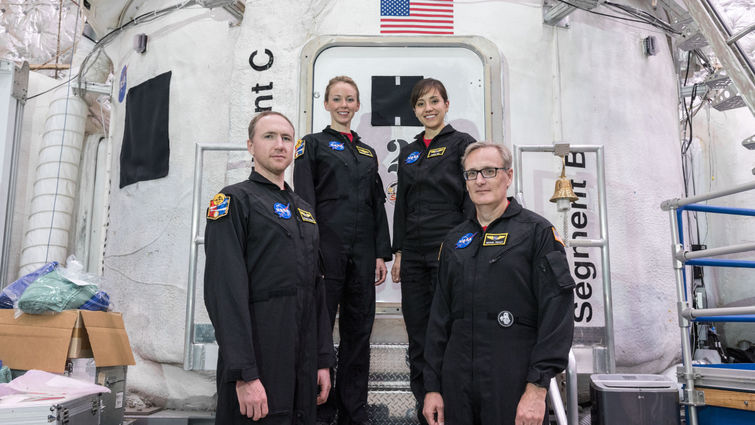While at NASA, four volunteers stand in front of the simulated shuttle they participated in for. 45 days.