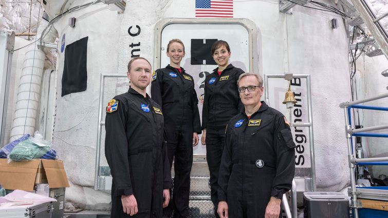 While at NASA, four volunteers stand in front of the simulated shuttle they participated in for. 45 days. 