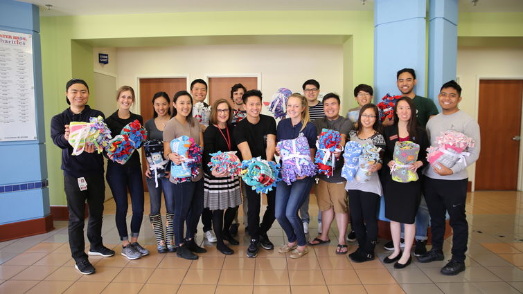 Dorothy Brooks, fifth from left, of child life services at LLU Children’s Hospital, accepted handmade blankets from LLU School of Pharmacy students on Wednesday, March 14. Group of people in a lobby holding gift blankets