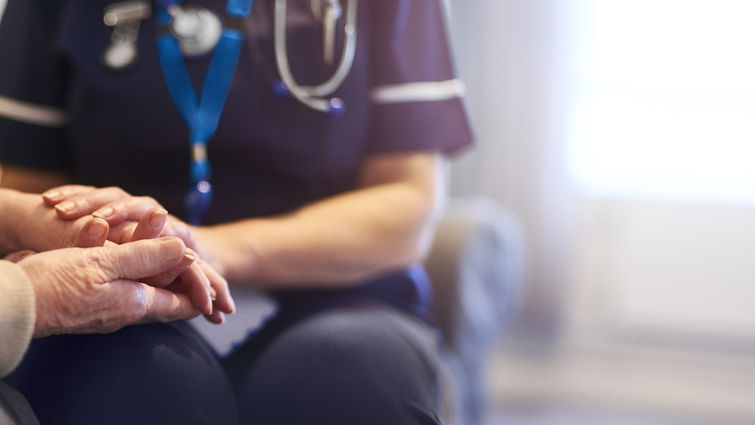 nurse holding patient's hand