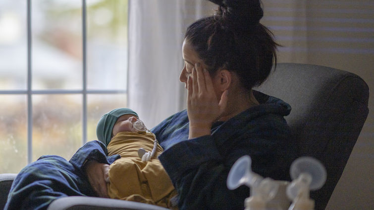 mother holding baby on rocking chair