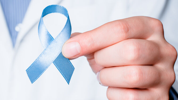 Blue ribbon in doctor hand.