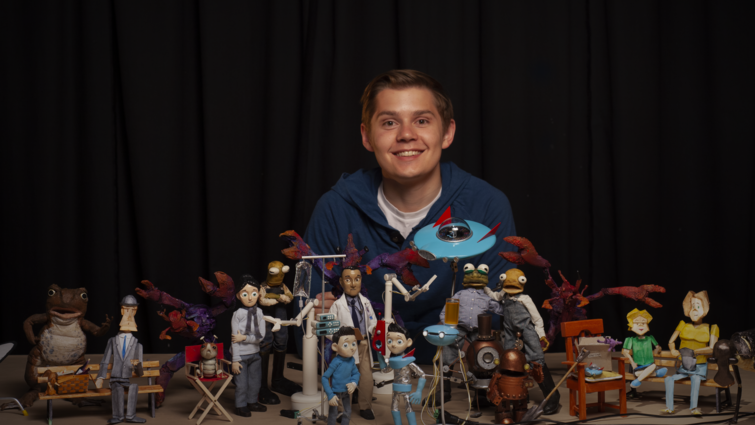 young man poses with claymation characters