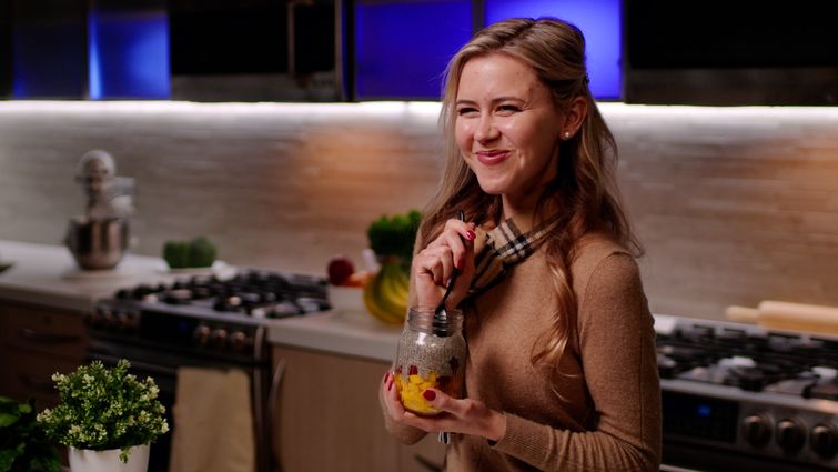 blonde Caucasian woman eating in kitchen