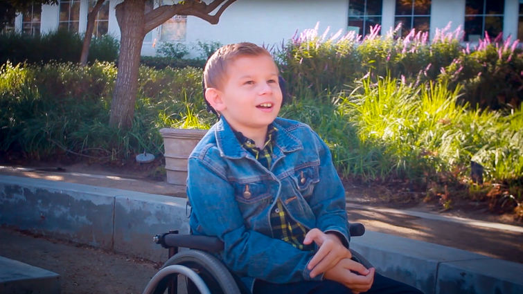 adolescent boy sitting outside in wheelchair