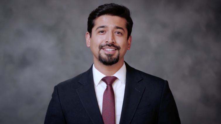 A man in a suit with a beard is smiling
