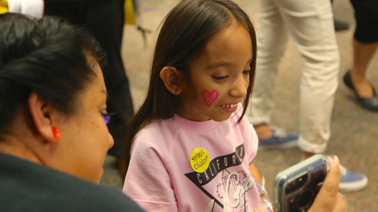 Loma Linda University Children’s Hospital patient Jennifer Alvarado, 9, of Fontana, gets a closer look at her face paint during the Spirit Fall Festival on Thursday, Oct 18.