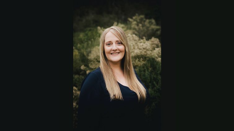 Headshot photo of Blonde Caucasion woman wearing black